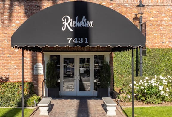 A building with a black awning that says Richelieu on it.