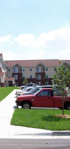 A red truck is parked in front of a building.