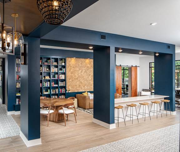 A modern living room with a bar area and a view of the outdoors.