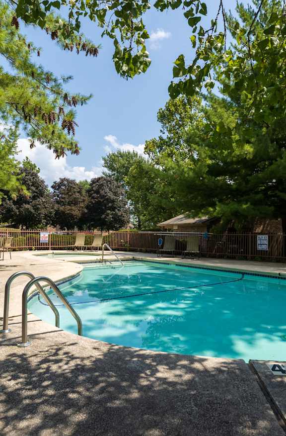 Multiple sparkling pools at Skyler Ridge Complex, surrounded by lounge chairs and lush greenery.