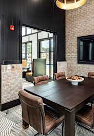 A modern dining room with a wooden table and chairs.