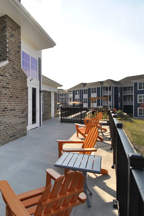 a patio with benches and tables in front of a building
