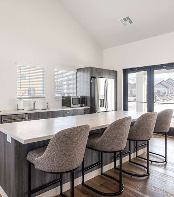 A kitchen with a bar area and chairs.