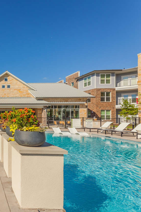 a swimming pool in front of an apartment building at sunset at Magnolia Grove Apartments, Terrell, 75160