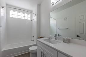A white bathroom with a toilet, sink, and bathtub.