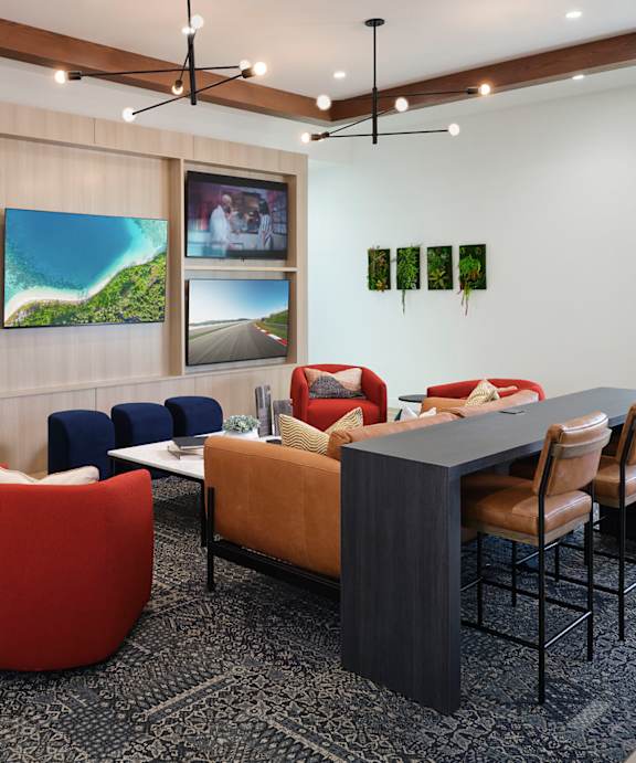 A modern living room with a grey sofa, red armchair and a black coffee table.
