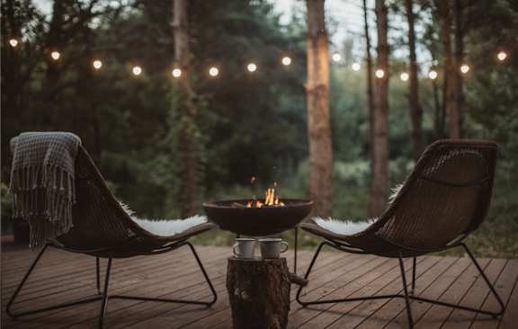 A cozy outdoor setting with two chairs and a table.