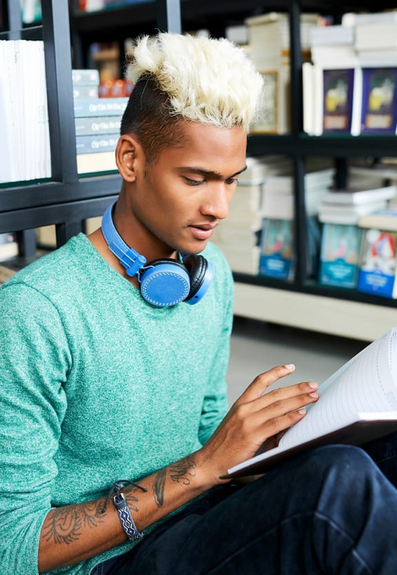 this is a photo of a young man reading at the local bookstore.