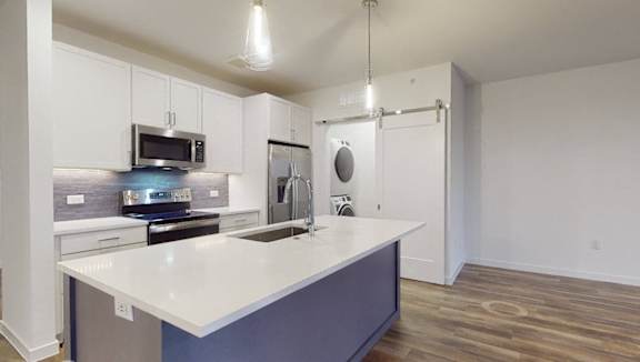 A modern kitchen with a white countertop and blue cabinets.