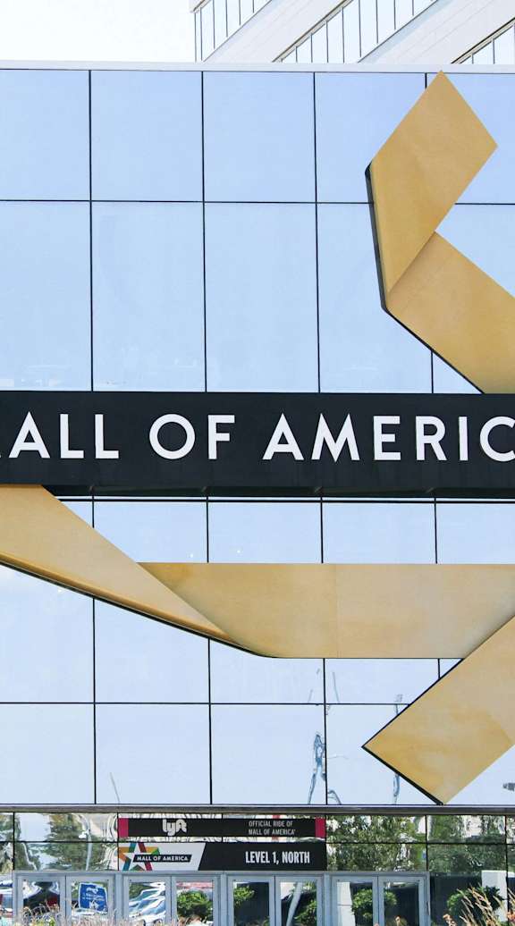 A large sign for the Mall of America is displayed in front of a building.