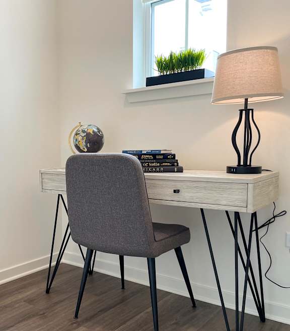 a bedroom with a desk and a chair and a dog sleeping on the floor at Enclave Crystal Lake Townhomes and Apartments, Crystal Lake, 60014