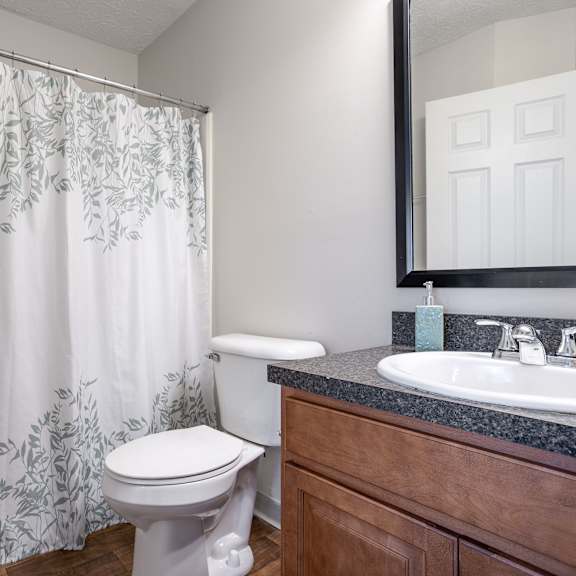 A white toilet sits next to a sink in a bathroom.