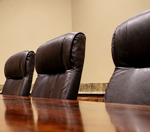 A conference room with a table and chairs.
