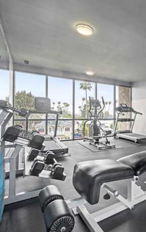 A gym with a variety of equipment including a leg press machine. at Lafayette Apartments, Los Angeles 90019