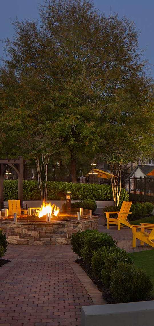a backyard with a fire pit and lounge chairs