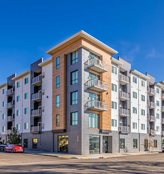 a tall apartment building with balconies and a blue skyat First Street Lofts in Downtown Bismarck, Bismarck, ND, 58506