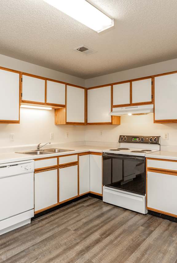 A kitchen with white appliances and wooden accents.