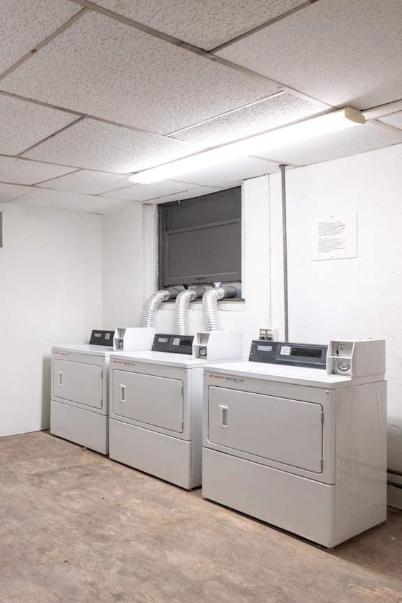 A laundry room with washers and dryers at Menlo Terrace Apartments, Los Angeles