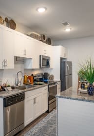 a kitchen with white cabinets and stainless steel appliances and a counter top