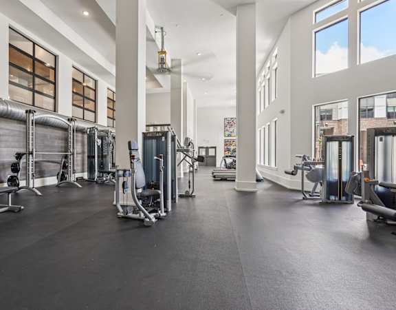 A spacious gym with a variety of equipment and a large mirror on the wall.