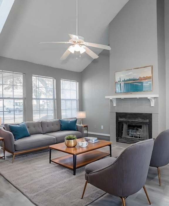 A living room with a grey couch, a coffee table, and a fireplace.