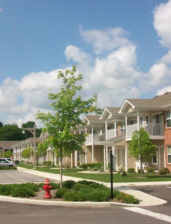 A street view of a residential area with houses and cars.