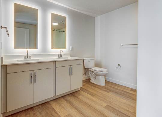 A bathroom with a toilet, sink, and mirror.