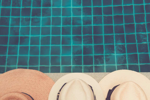 Hats on the side of a pool