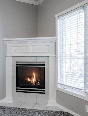 A fireplace with a white mantle and a fire burning inside. at Diamond Brooke, Iowa, 50266