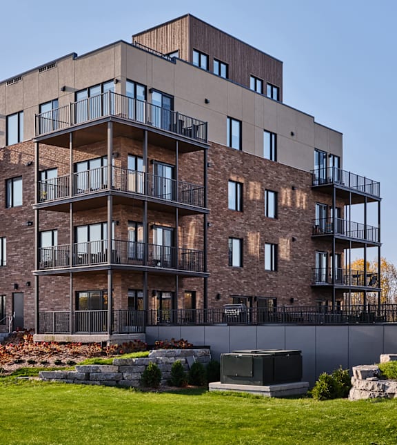 A large, modern apartment building with balconies and a mix of brick and siding exterior.