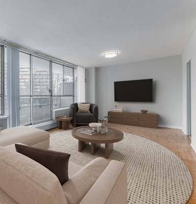 A living room with a large couch, a coffee table, and a flat screen TV.