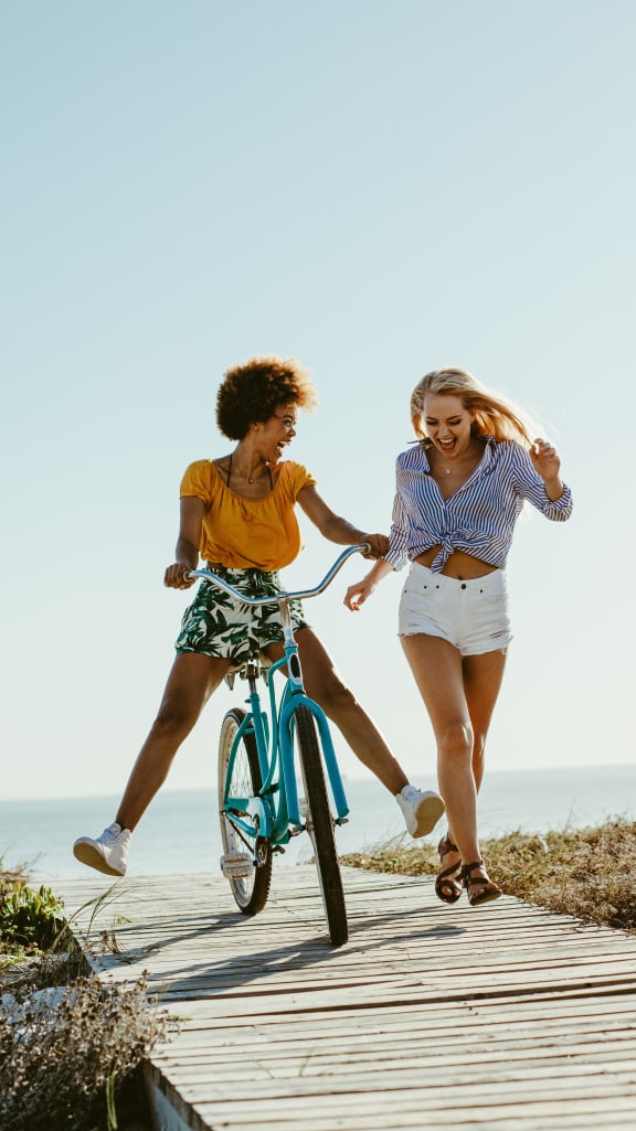 Lifestyle photo of two woman at the beach with a bicycle at Valencia Pointe, Miami, Florida