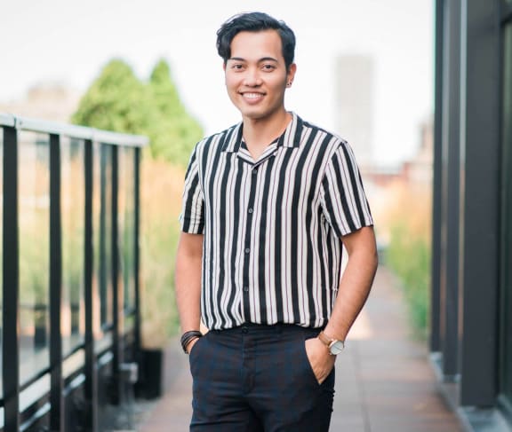 a young man wearing a striped shirt and jeans