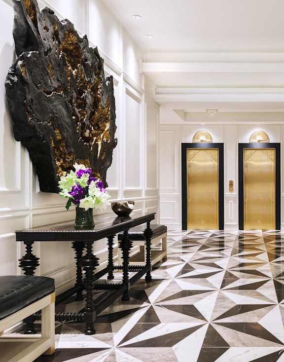 A black and white tiled floor with a gold and black chair.