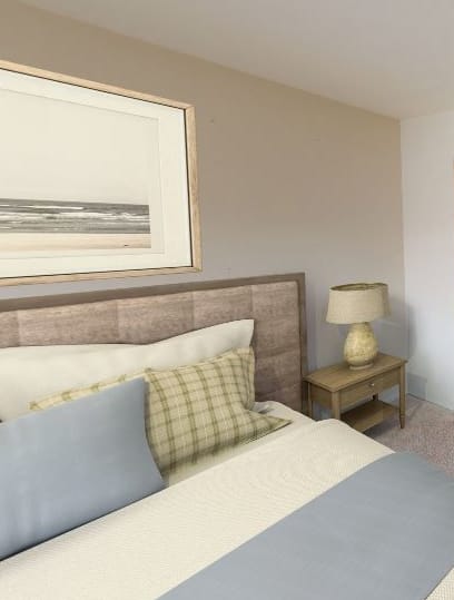 a bedroom with a bed and a desk with a laptop