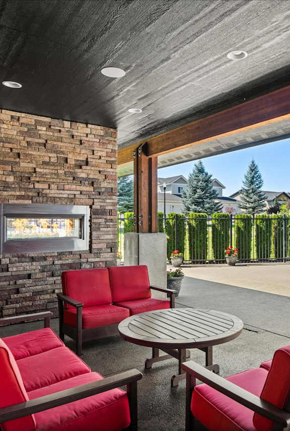 A patio with a table, chairs, and fireplace.