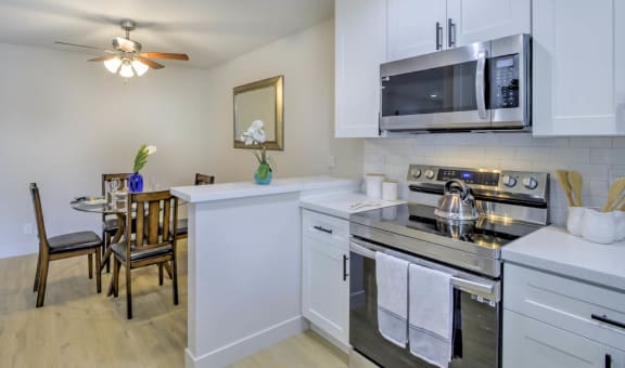a kitchen with white cabinets and stainless steel appliances