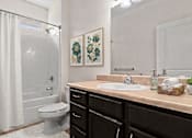 Thumbnail 8 of 28 - A bathroom with a toilet, sink, and a mirror.