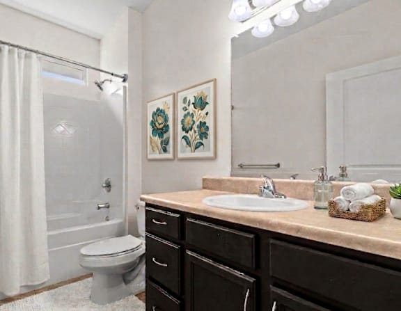 A bathroom with a toilet, sink, and a mirror.