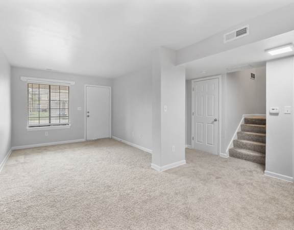 A spacious room with a carpeted floor and a staircase leading to another room.at Eagles Edge Apartments, Indianapolis, IN 462542