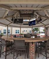 A patio with a table and chairs under a roof.
