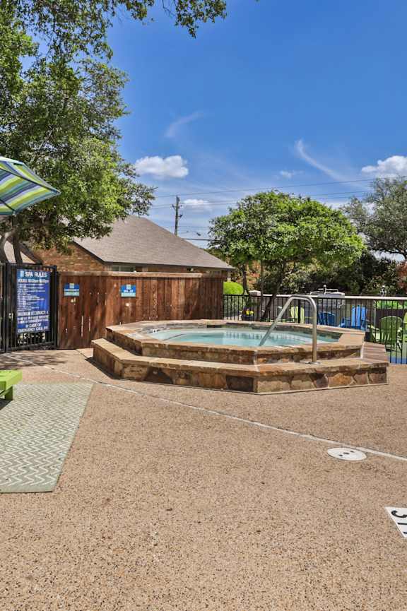 A pool area with a hot tub and chairs.