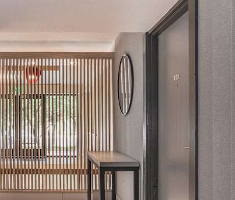 a hallway with a table and a mirror on the wall