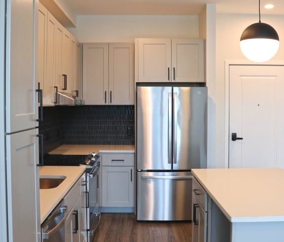 a renovated kitchen with stainless steel appliances and white cabinets at Wildhorse Apartments, Chesterfield, 63017