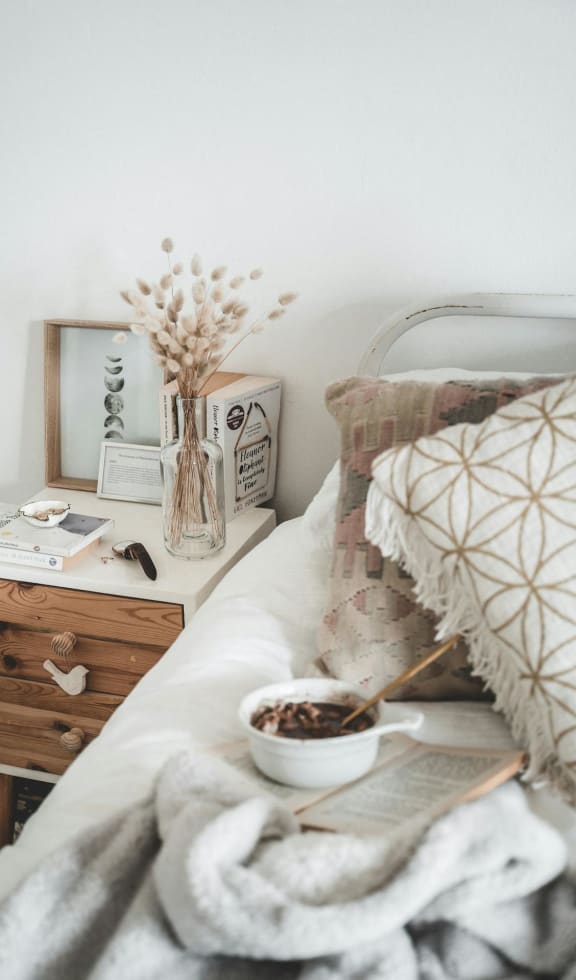 A bedroom with a bed and a bowl of coffee on it.