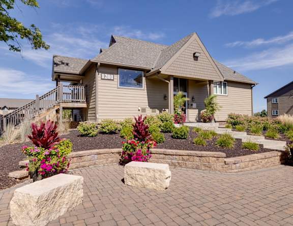 Clubhouse at Olde English Village with driveway and landscaped front entrance.