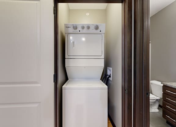 a stacked washer and dryer in a closet space