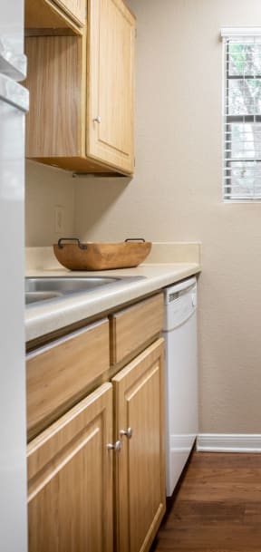 a kitchen with white appliances and wooden cabinets at Summit Ridge Apartments, Temple, Texas