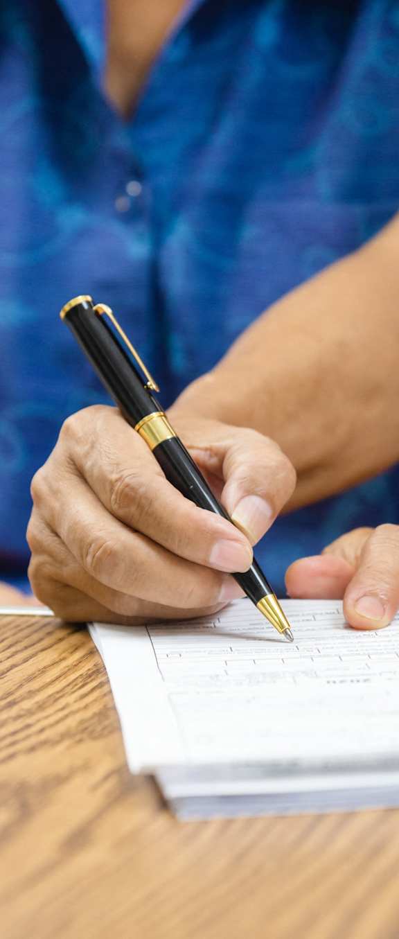 a student writing on a piece of paper with a pen