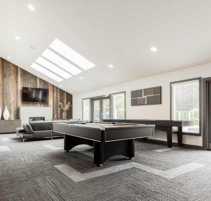 A spacious room with a long table and chairs.